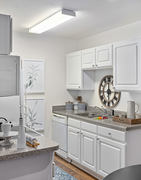 Side view of modern kitchen next to dining area, with white cabinets and granite countertops at MAA Legacy Park luxury apartments in Charlotte, NC