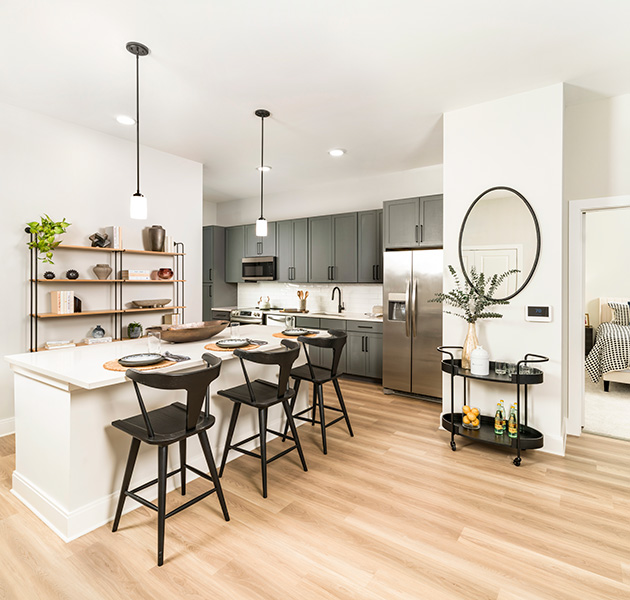 Modern apartment kitchen with spacious kitchen island and modern finishes on wood floors at MAA Liberty Row luxury apartments in Charlotte, North Carolina.
