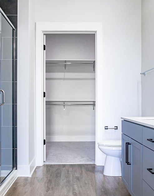 Bathroom with walk-in closet and warm-toned wood floors at MAA LoSo luxury apartments in Charlotte, NC
