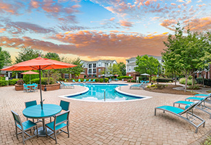 Poolside lounge chairs surrounded by lush bushes at MAA Matthews Commons luxury apartments in Matthews, NC