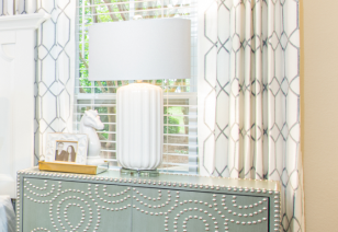 Bedroom with stylish lamp on night stand next to a large window with blinds at MAA Prosperity Creek luxury apartments in Charlotte, NC