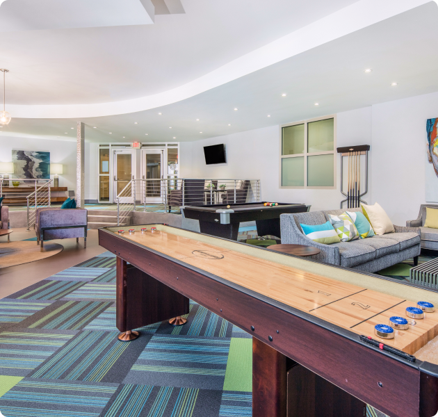 Community resident lounge area with billiards table, shuffleboard table and multiple sitting areas at MAA South Line luxury apartments in Charlotte, NC