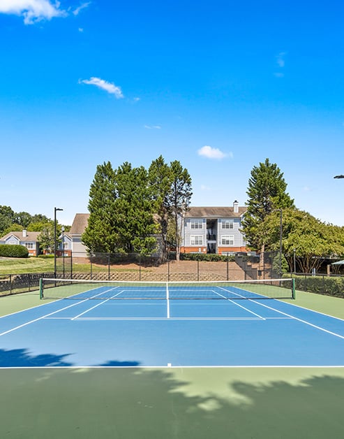 Tennis court surrounded by lush greenery at MAA University Lake luxury apartments in Charlotte, NC