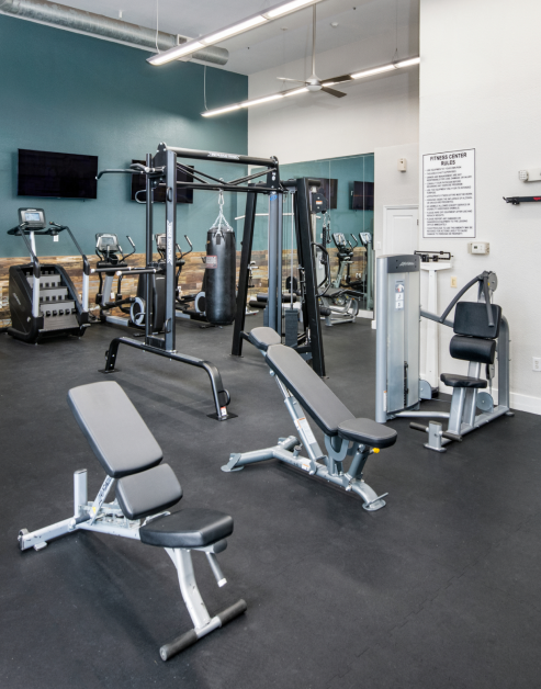 Fitness center with ceiling fans, wall mounted TVs and variety of workout equipment at MAA Uptown luxury apartments in Charlotte, NC