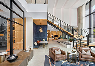 Clubhouse with unique baffle ceilings and light fixtures, coffee bar and multiple sitting areas next to large picture windows at MAA Nixie luxury apartments in Durham, NC