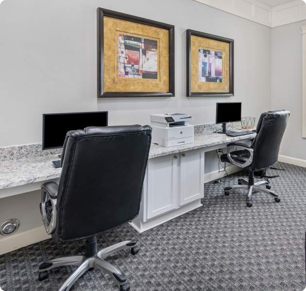 Clubhouse business center with communal workstations with wall art at MAA Providence luxury apartments in Raleigh, NC.