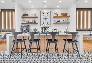 Clubhouse coffee bar with shelving and dark grey metal bar top chairs at MAA Vale luxury apartments in Raleigh, NC