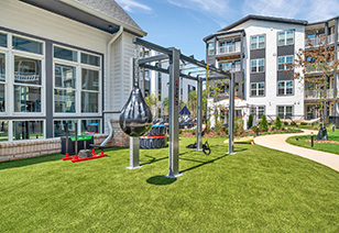 Outdoor fitness gym station on a grass lawn with a weighted punching bag at MAA Vale luxury apartments in Raleigh, NC