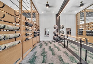 Fitness center with yoga mat wall rack and exercise ball rack next to a mirrored wall at MAA Vale luxury apartments in Raleigh, NC