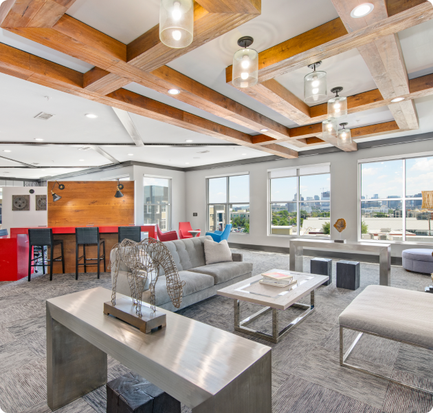 Upstairs community lounge room with wood beam ceiling with modern light fixtures, coffee bar and multiple sitting areas with skyline city views at MAA Charlotte Ave luxury apartments in Nashville, TN