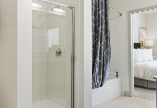 Close up of modern en suite bathroom with bathtub and dark patterned shower curtains at MAA Charlotte Ave luxury apartments in Nashville, TN