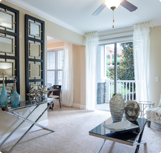 Model apartment with open living and dining area next to sliding glass doors with a view of the veranda at MAA Cool Spring luxury apartments in Franklin, TN
