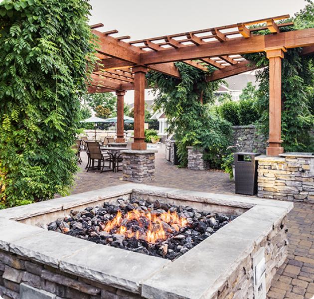 Outdoor community open wooden pergola with fire pit and multiple siting areas surrounded by greenery at MAA Cool Spring luxury apartments in Franklin, TN