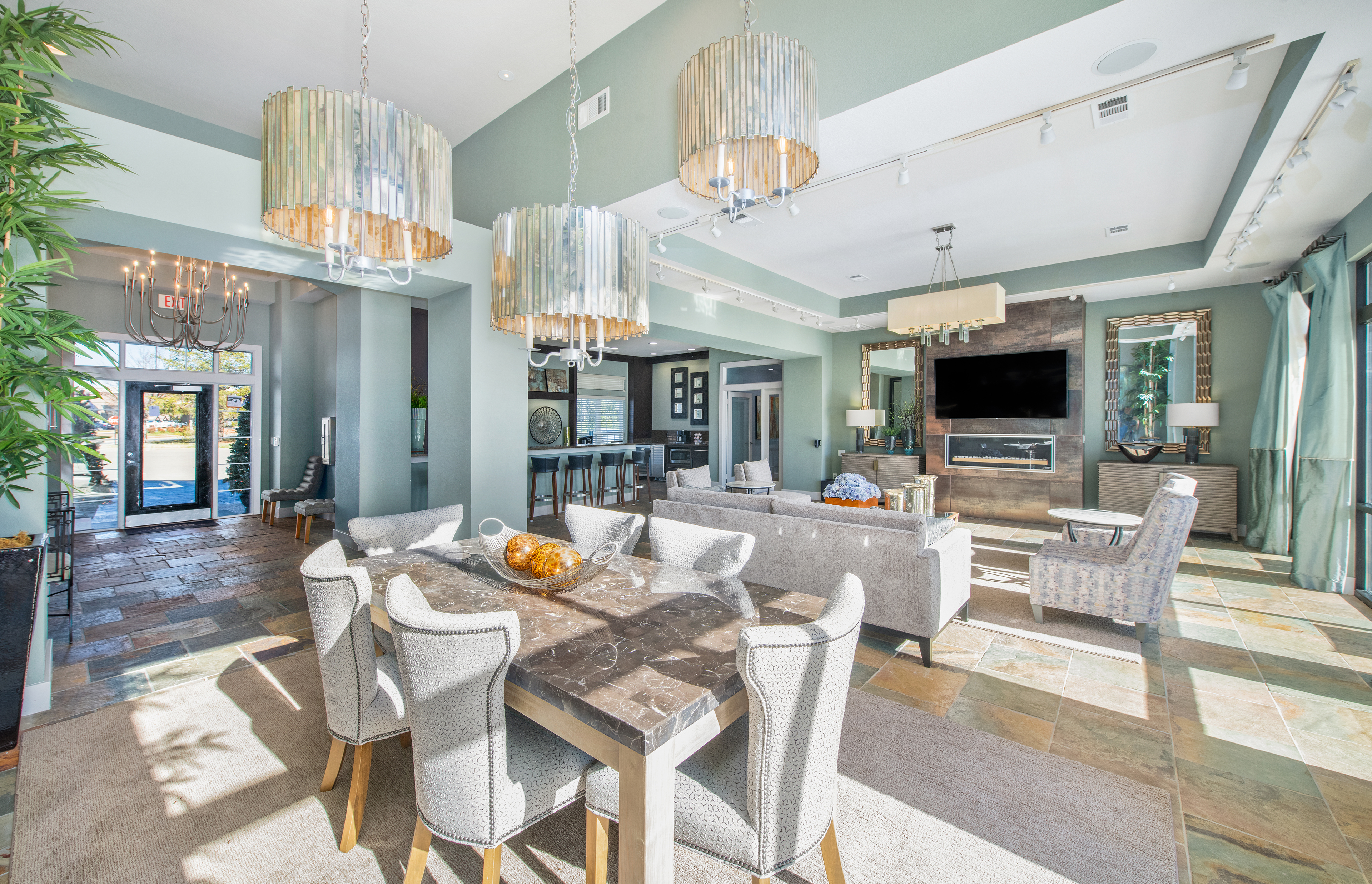 Modern glam-style community clubhouse with multiple chandeliers, coffee bar and kitchen with multiple sitting areas at MAA Indian Lake luxury apartments in Hendersonville, TN