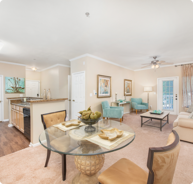 Model apartment with large open space living area with French doors, ceiling fan and multiple siting area next to the kitchen and dining area at MAA Monthaven Park luxury apartments in Hendersonville, TN