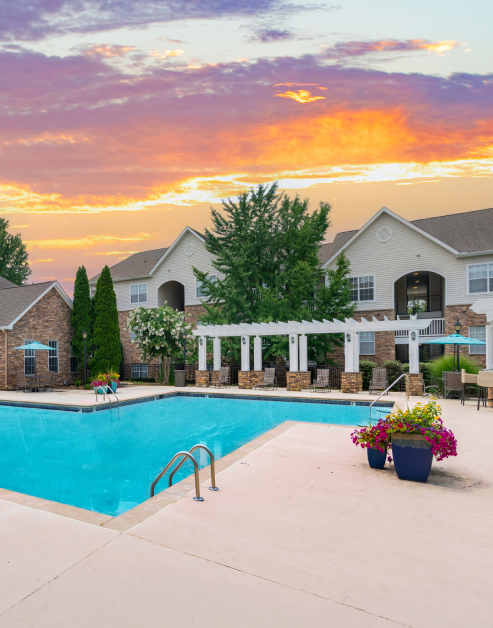 Resort-style pool with metal handrails, lounge chairs and pergola next to lush trees at MAA Monthaven Park luxury apartments in Hendersonville, TN