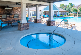 A pool side round soaking spa next to a covered patio at MAA Murfreesboro luxury apartments in Murfreesboro, TN