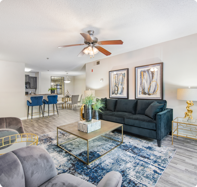 Model apartment living room with ceiling fan and sitting area next to the open kitchen at MAA Nashville West luxury apartments in Nashville, TN