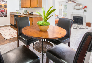 Carpeted dining area next to the kitchen with wooden round dining table and black cushioned chairs at MAA Park luxury apartments in Hermitage, TN