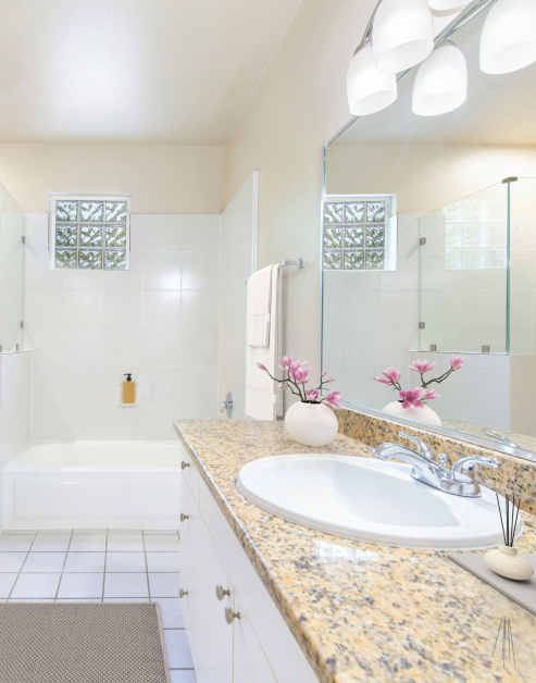 A modern bathroom featuring a sink, a relaxing bathtub, and tile floors at MAA Abbey luxury apartments in Dallas, TX