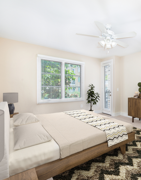 Charming bedroom layout showcasing a plush bed and a ceiling fan at MAA Abbey luxury apartments in Dallas, TX