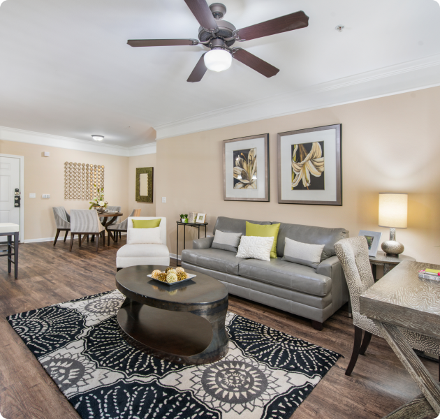 A modern living room with a sofa and coffee table with hardwood floors and a ceiling fan at MAA Fairview luxury apartments in Fairview, TX