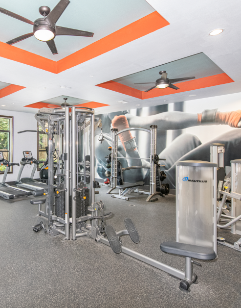 State-of-the-art fitness center with gym equipment and ceiling fans at MAA Frisco Bridges luxury apartments in Frisco, TX