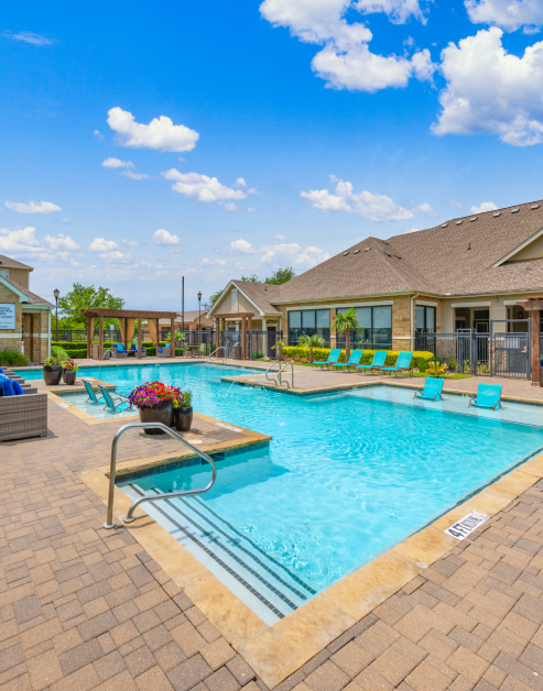 Stunning swimming pool with lounge chairs and sundeck surrounded by potted plants at MAA Hebron luxury apartments in Carrollton, TX