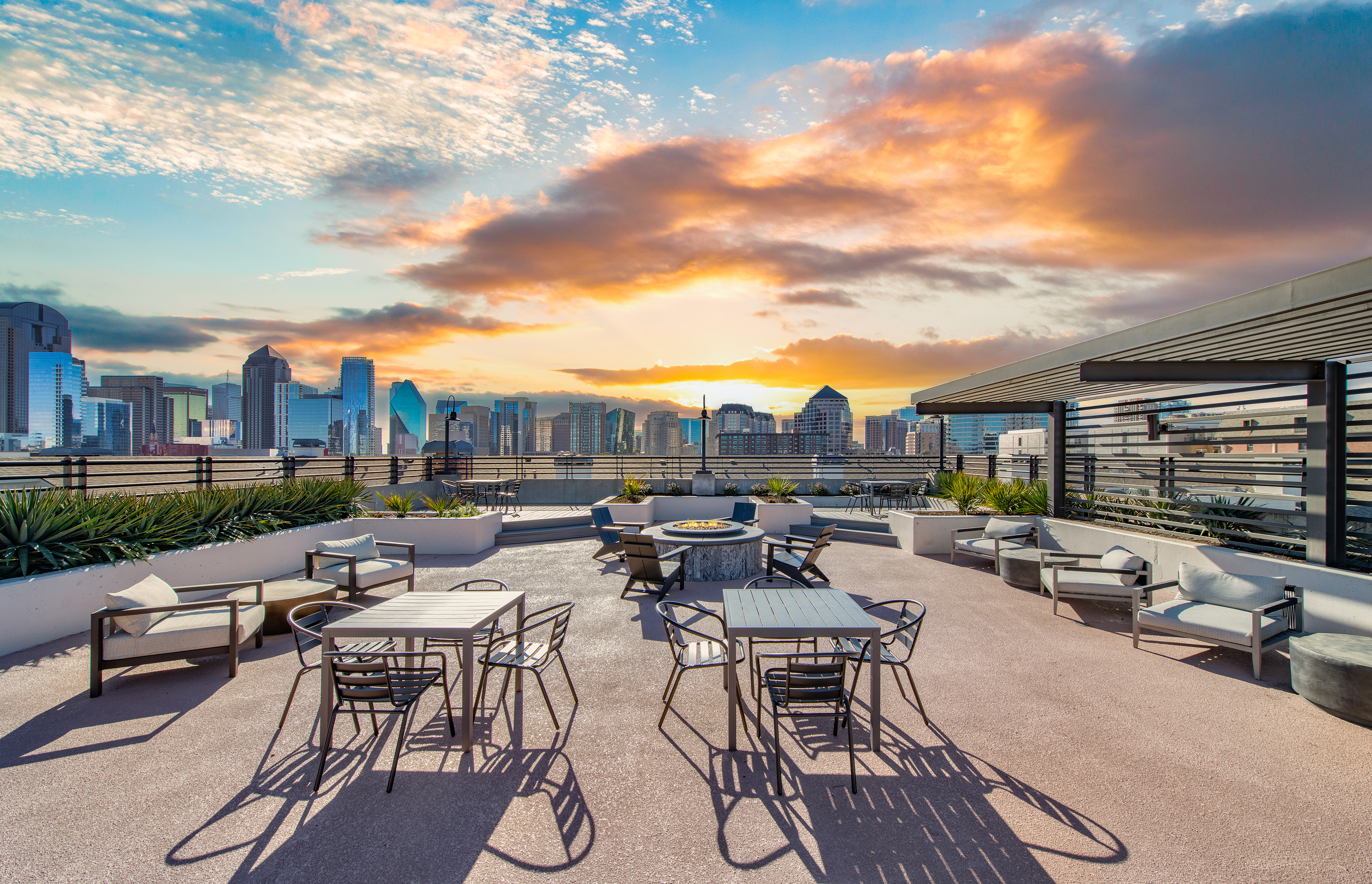 Rooftop terrace with a skyline view and outdoor seating, a fire pit, and potted plants at MAA Heights luxury apartments in Dallas, TX