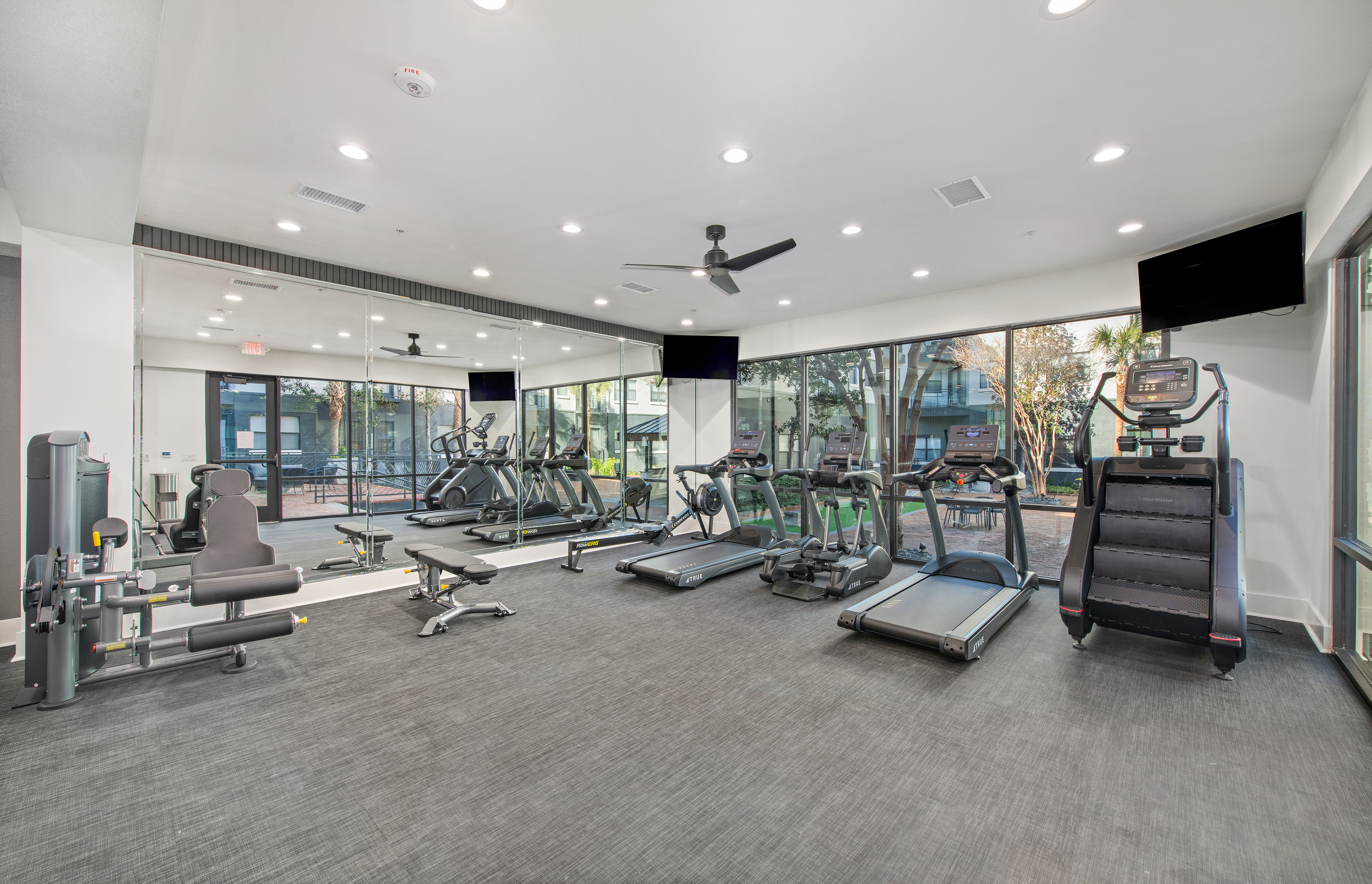 Fitness center features treadmills, a stair climber, and large picture windows at MAA Heights luxury apartments in Dallas, TX