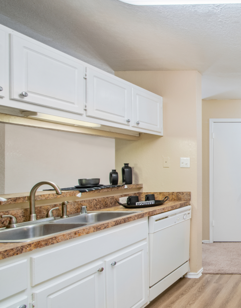 A stylish modern kitchen showcasing white cabinetry and a contemporary sink at MAA Highwood luxury apartments in Plano, TX