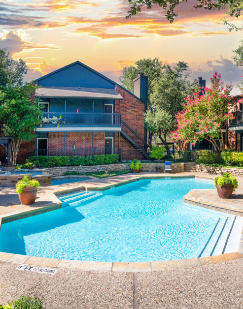 Swimming pool nestled within a landscaped courtyard next to flowering trees at MAA Highwood luxury apartments in Plano, TX