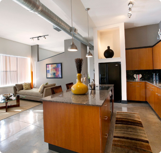 Open loft-style apartment with a modern kitchen with island countertop and living area at MAA Las Colinas luxury apartments in Irving, TX