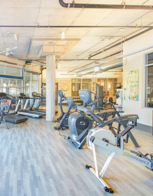 Fitness center with wood flooring and gym equipment at MAA Las Colinas luxury apartments in Irving, TX