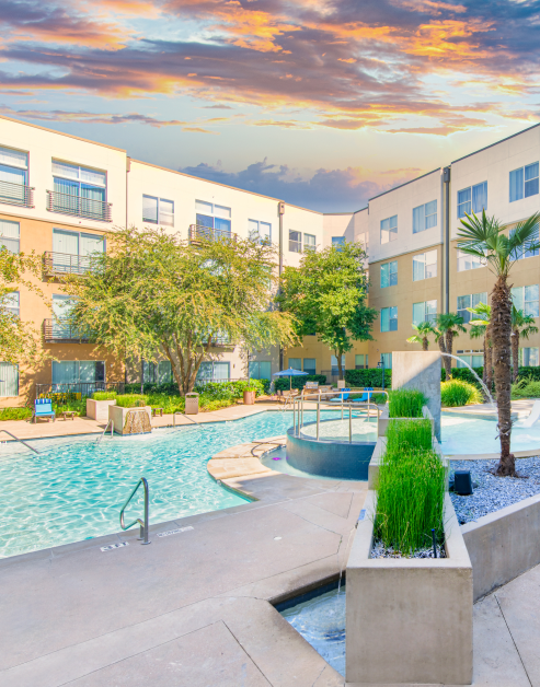 Modern swimming pool with hot tub surrounded by lush trees and greenery at MAA Las Colinas luxury apartments in Irving, TX