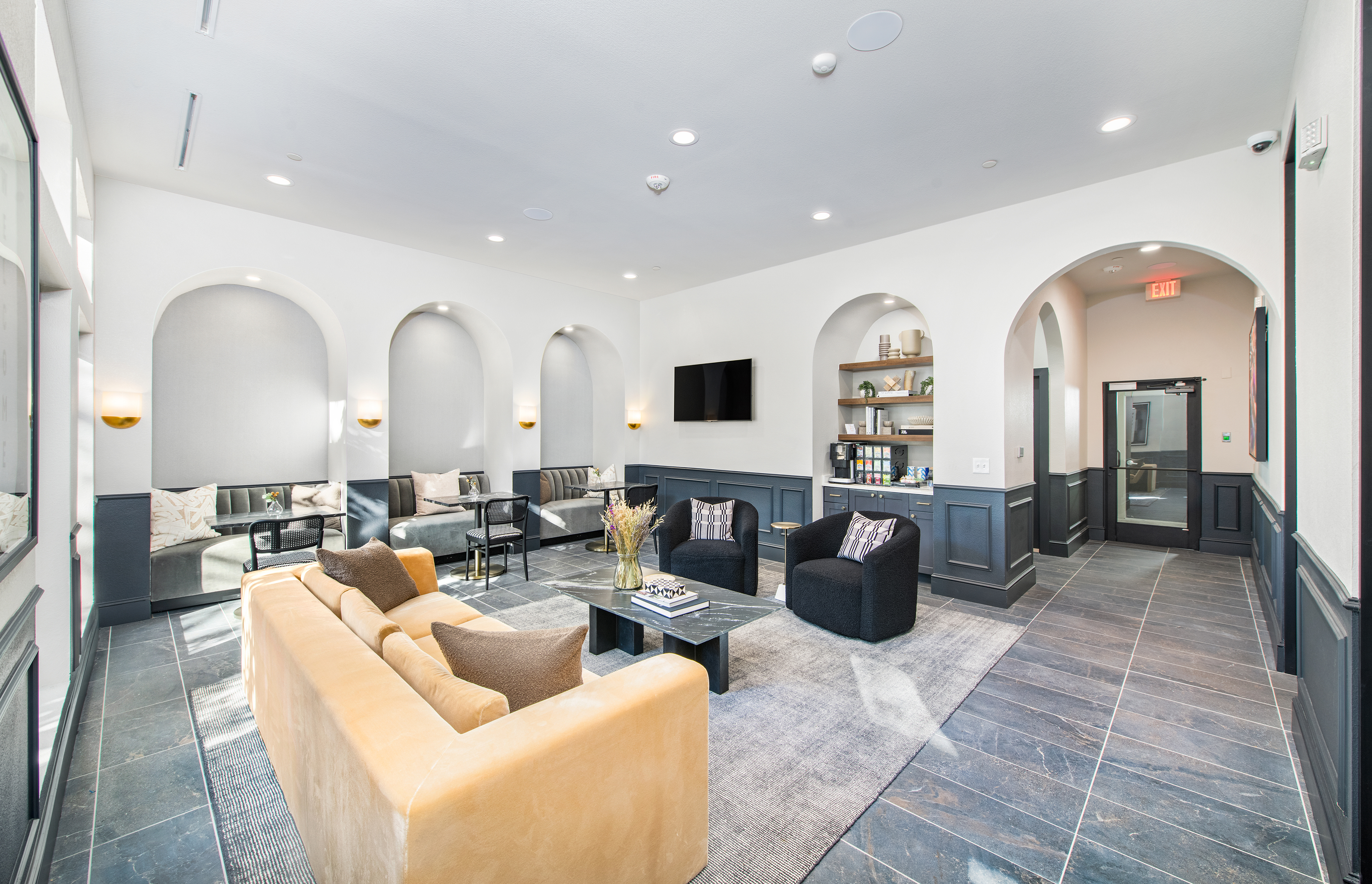 Modern community clubhouse and leasing office with large lounge sitting area and coffee station at MAA Legacy luxury apartments in Plano, TX