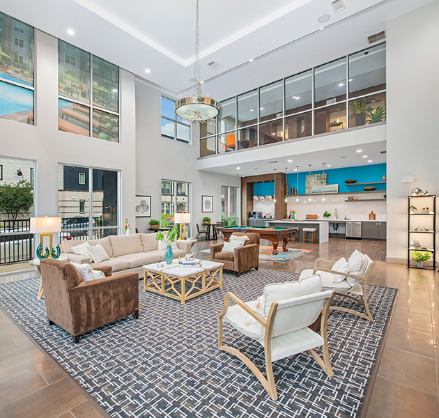Lavish grand community clubhouse with multiple seating areas, pool table and open kitchen with coffee bar at MAA Market Center luxury apartments in Plano, TX