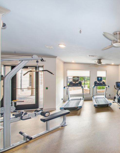A luxurious fitness center featuring state-of-the-art exercise equipment and a ceiling fan at MAA Meridian luxury apartments in Dallas, TX
