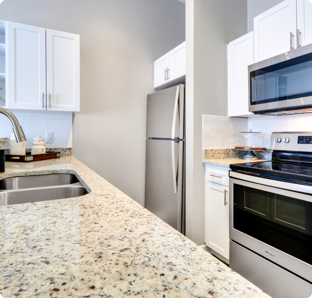 Bright kitchen adorned with stainless steel appliances and polished granite countertops at MAA North Hall luxury apartments in Dallas, TX