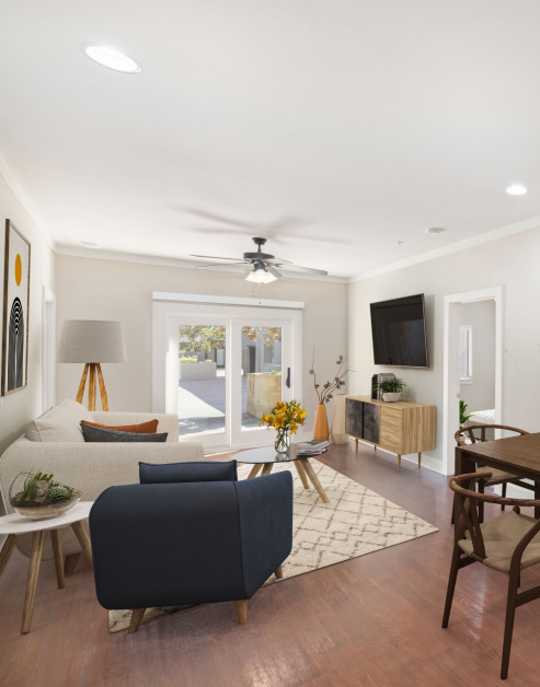 A stylish living room featuring a comfortable couch, a ceiling fan and recessed ceiling lighting with wood flooring at MAA Times Square luxury apartments in McKinney, TX
