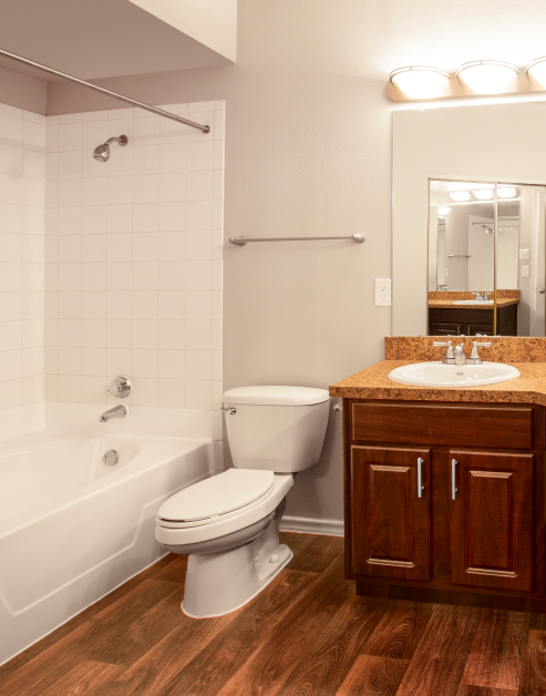 Stylish bathroom with wood floors and tiled bathtub at MAA Valley Ranch luxury apartments in Irving, TX
