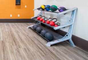 A fitness center featuring a rack of dumbbells and kettlebells at MAA Watermark luxury apartments in Roanoke, TX
