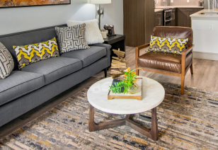 Close up of living room area with a couch, armchair and marble round coffee table at MAA Afton Oaks luxury apartments in Houston, TX