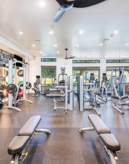 24/hr fitness center with ceiling fans, large windows and various exercise machines at MAA Greater Heights luxury apartments in Houston, TX