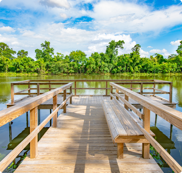 Community wood boat docking deck with lake view surrounded by lush greenery at MAA Legacy Pines luxury apartments in Houston, TX