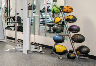 Close-up view of fitness center weighted ball rack next to wall mirror at MAA Midtown Square luxury apartments in Houston, TX