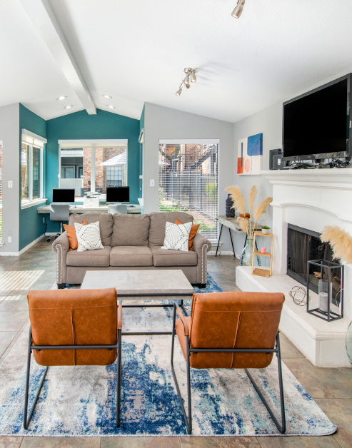 Community clubhouse with vaulted ceilings, internet café and lounge sitting area next to a TV and fireplace at MAA Valleywood luxury apartments in the Woodlands, TX