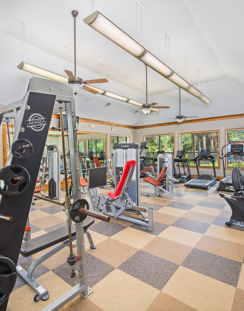 Fitness center with ceiling fans and modern gym equipment next to large windows at MAA Westover Hills luxury apartments in San Antonio, TX
