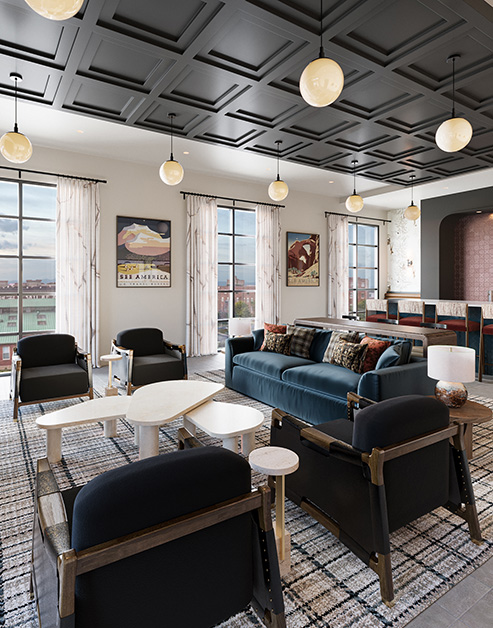 Rooftop clubhouse lounge area with blue sofas on a patterned rug with large windows and a bar-top kitchen area at MAA Rove luxury apartments in Richmond, VA