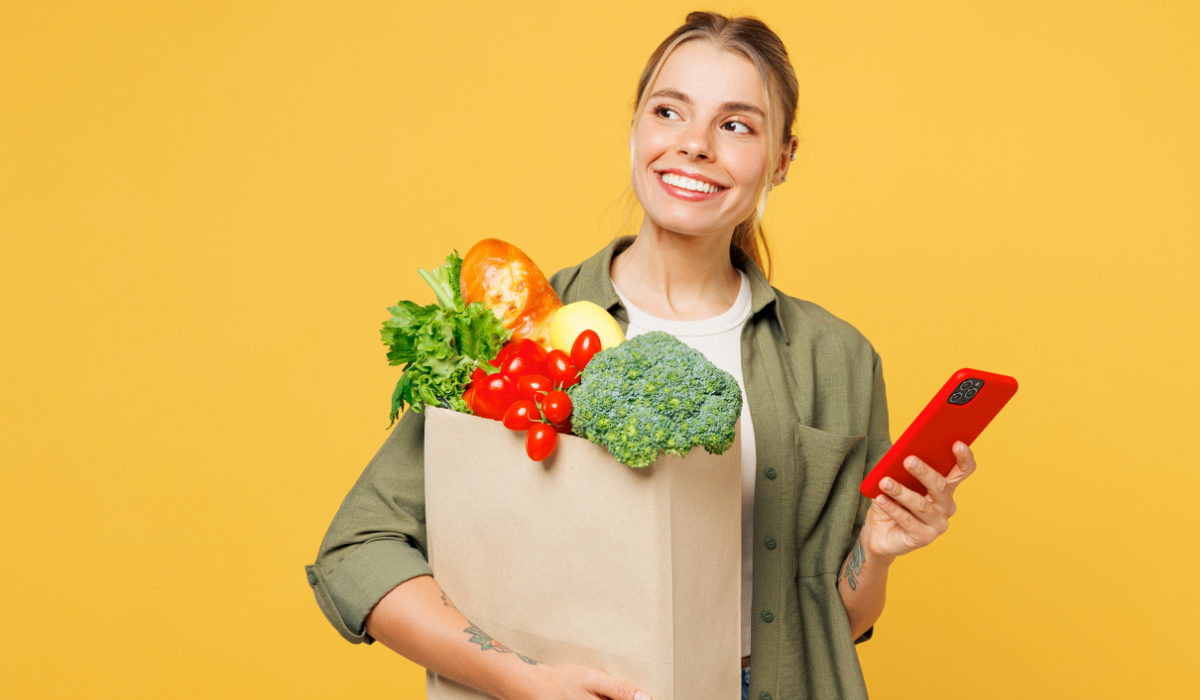 Woman holding groceries and phone